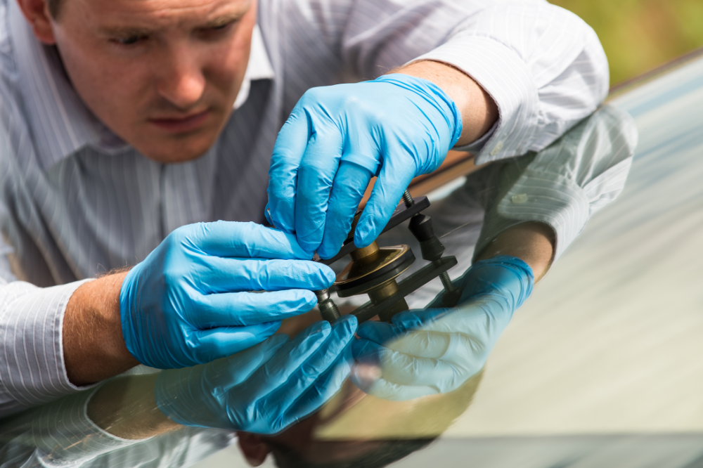 Professional repairing a windshield using advanced tools as part of rock chip repair services, ensuring a high-quality and durable fix.